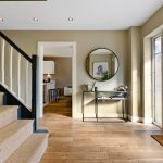 Bright hallway with staircase and large mirror