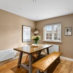Cosy dining room with wooden furniture and art.