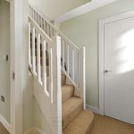 Carpeted staircase with white railing and closed door.