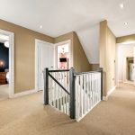 Modern home hallway with open doors and stairs.