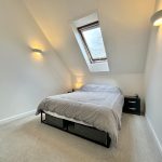 Cosy attic bedroom with grey bedding.