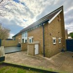 Modern brick house with spacious paved patio area.
