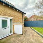 Brick house with white door and garden patio.
