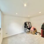 Spacious room with clothes rail and suitcases.