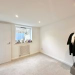Minimalist room with natural light and clothes rack.