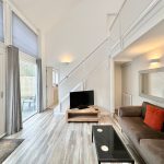 Modern living room with large windows and stylish decor.