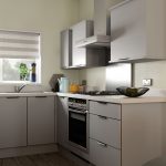 Modern kitchen with grey cabinets and large window.