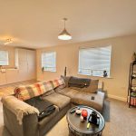 Modern living room with sofa and kitchen area.