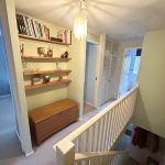 Hallway with bookshelves and stairs in a home.