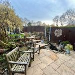 Garden patio with benches and decorative plants.