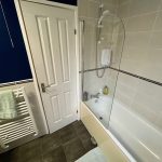Modern bathroom with bath and towel radiator.