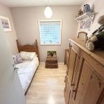 Small bedroom with wooden furniture and soft toys.