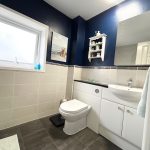 Modern bathroom with blue walls and white fittings