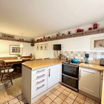 Cosy kitchen with dining area and wooden accents.