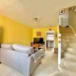 Cosy living room with staircase and vibrant decor.