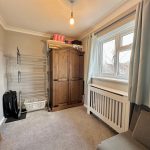 Small room with wardrobe, radiator, and window.
