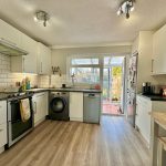 Modern kitchen with appliances and garden view.