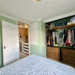 Cosy bedroom with green walls and wardrobe.