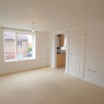 Bright empty room with window and doorway view.