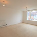 Bright empty room with window overlooking buildings.