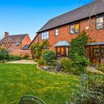 Large red brick house with garden in the UK.
