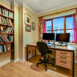 Cosy home office with bookshelves and computers.
