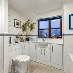 Modern bathroom with shower, sink, and window.
