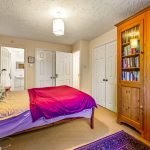 Cosy bedroom with bookshelves and double bed.