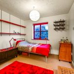 Bedroom with red accents and white walls.
