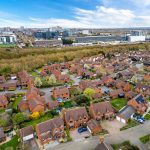 Aerial view of suburban houses and greenery.