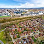 Aerial view of suburban UK housing estate and cityscape.