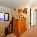 Upstairs hallway with window and chest of drawers.