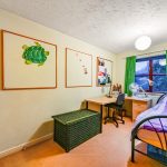 Cosy bedroom with desk and colourful decor.