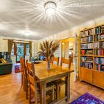 Cosy living room with bookshelves and dining table.