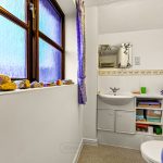Cosy bathroom with purple accents and decorative elements.