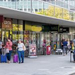 Shoppers walking past Costa Coffee and M&S.