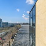 Modern office buildings with glass windows, clear sky view.