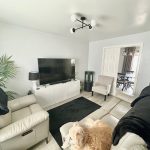 Modern living room with TV and light decor.