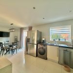 Modern kitchen with dining area and appliances.
