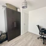 Minimalist office with wardrobe and desk setup.