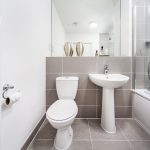 Modern bathroom with sink, toilet, and shower.