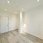 Minimalist room with wooden floor and white walls.
