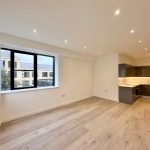 Modern open-plan kitchen and living space with window.