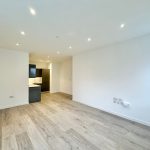 Modern empty living room with kitchen area.