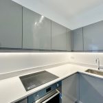 Modern kitchen with grey cabinets and appliances.