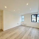 Spacious modern flat with wooden flooring and windows.