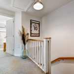 Indoor hallway with staircase and decorative jersey frame.