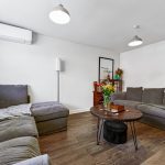 Modern living room with grey sofas and flowers.