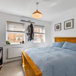 Cosy bedroom with blue bedding and TV.
