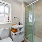 Modern bathroom with shower and toiletries.